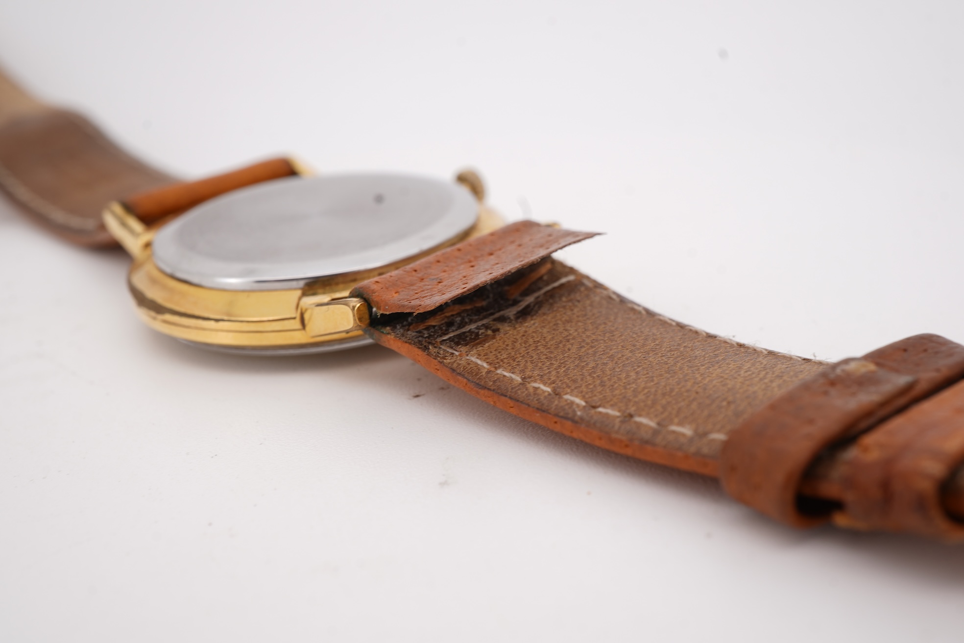 A gentleman's steel and gold plated Bulova Longchamp manual wind wrist watch, with baton numerals, case diameter 33mm, on a tanned leather strap.